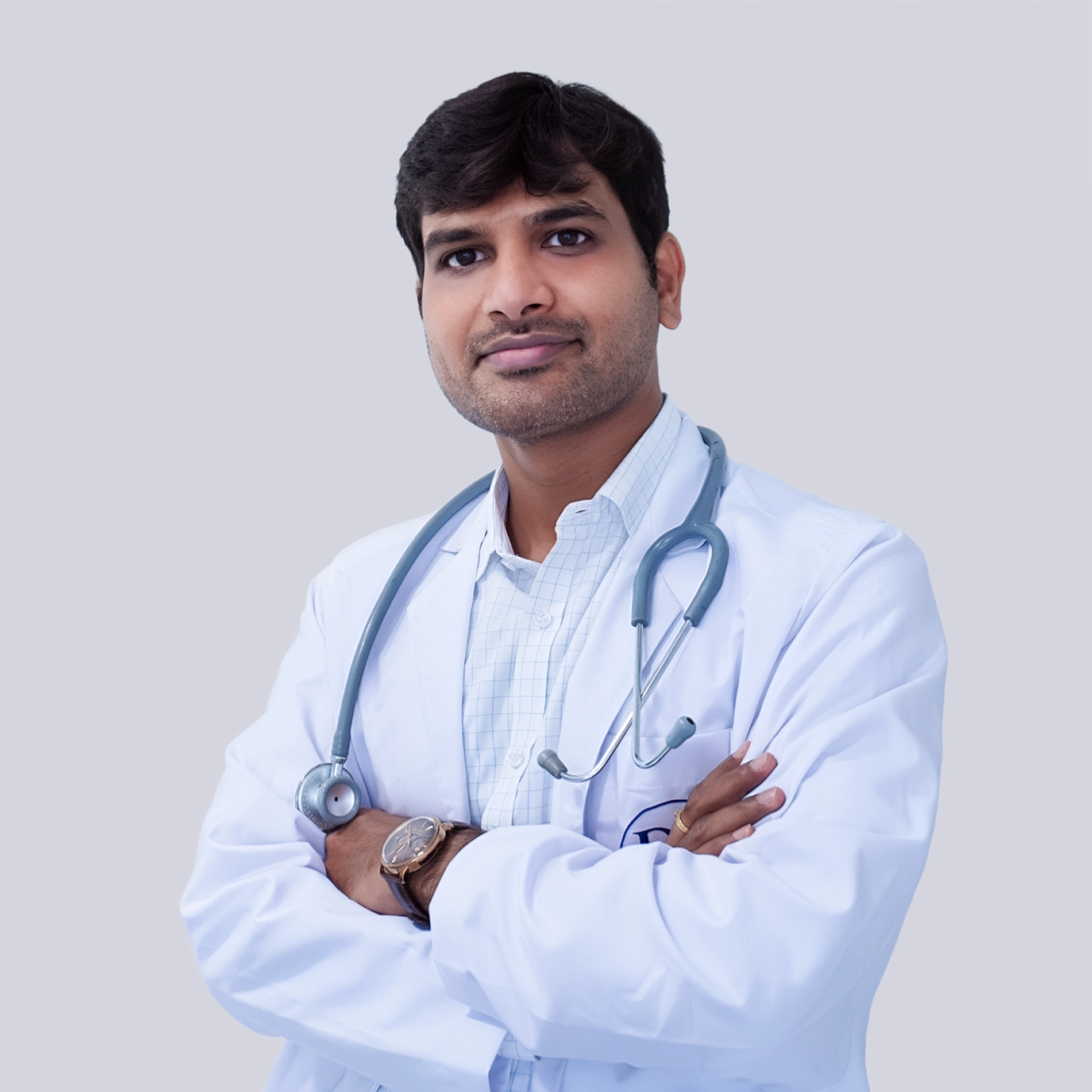 Portrait of Dr. G. Naresh, a male medical oncologist wearing a white coat and stethoscope, smiling, vertical rectangle photo